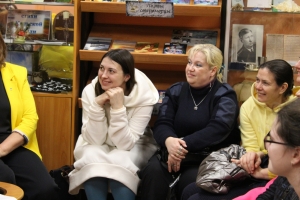 Коллеги Елены Петровны и просто любители поэзии слушают стихи в исполнении автора