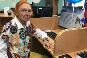 Участница акции знакомится с мультимедийной презентацией